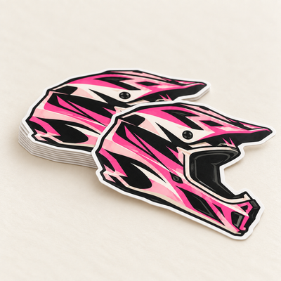 AI-generated illustration: Close-up of a shallow stack of matching pink-and-black helmet die-cut stickers with fine layered edges and one loose sticker in front.