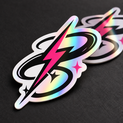 AI-generated illustration: Black-and-pink lightning-loop die-cut stickers on a dark surface, showing smooth rainbow bands from a transparent Prismatic overlaminate over opaque white vinyl.
